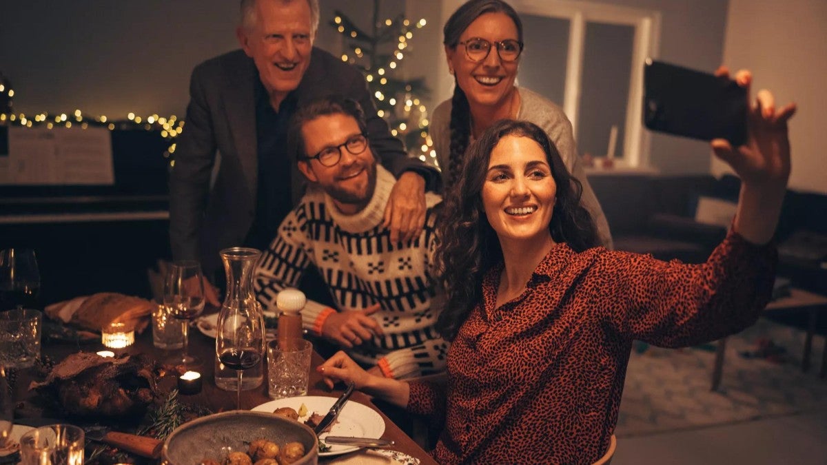 Family taking a selfie at the table in their home.