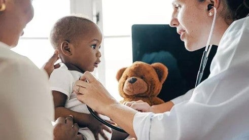 A doctor providing a checkup to a young child A doctor providing a checkup to a young child
