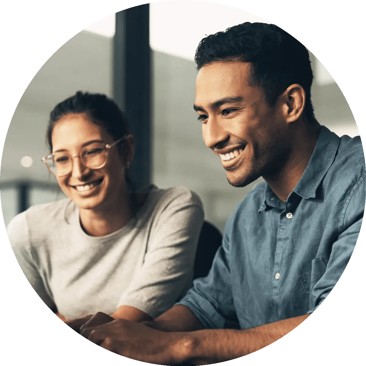 A man and woman smiling looking at a computer.