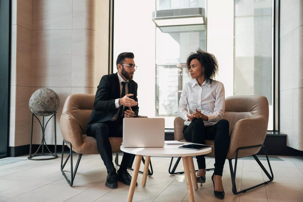 Business insurance solutions Man and woman meeting in an office setting.