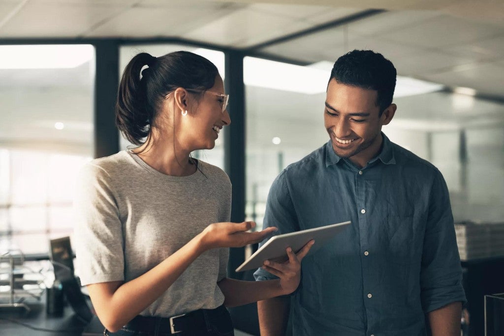 Nonqualified deferred compensation plans A man and a woman talking in an office setting.