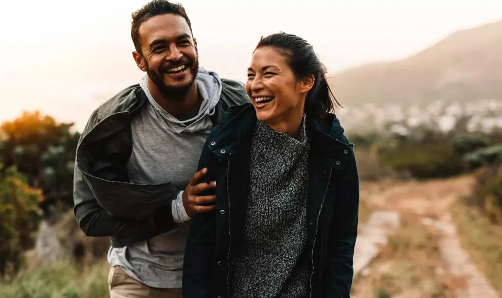 A happy man and woman going for a walk outdoors.