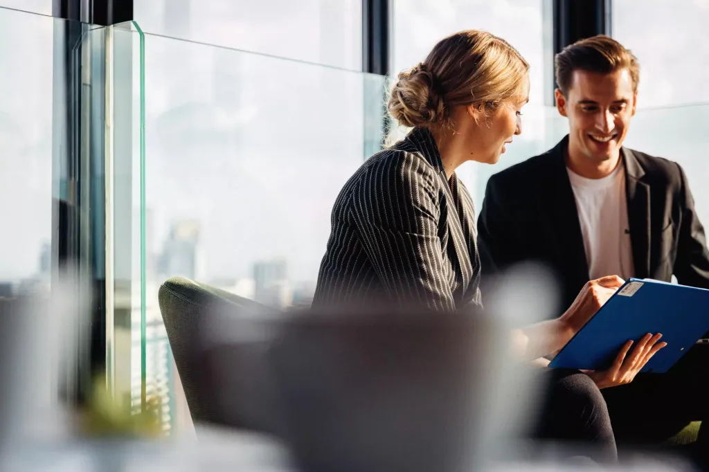 A man and woman meeting in an office environment.