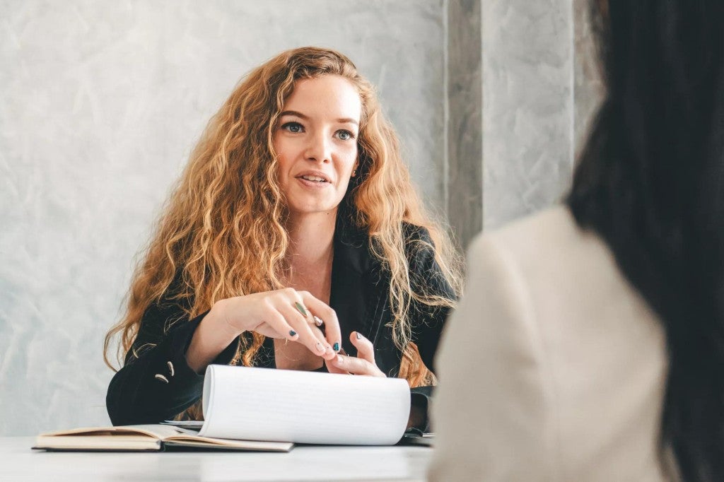 registered-index linked annuity options Woman in a meeting room speaking to another person with their back to the camera.