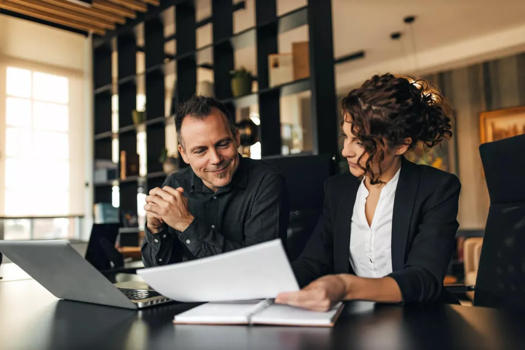 A man and a woman meeting in an office setting.