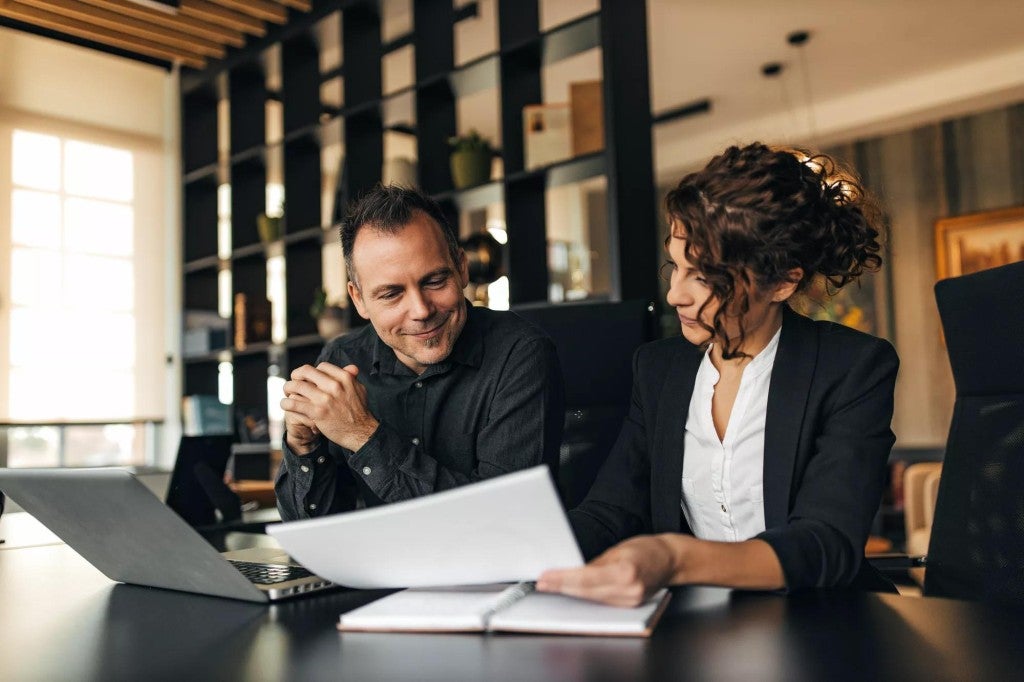 Executive benefits offering A man and a woman meeting in an office setting.