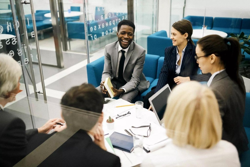 Executive benefits offering A group of young professionals meeting in an office setting.