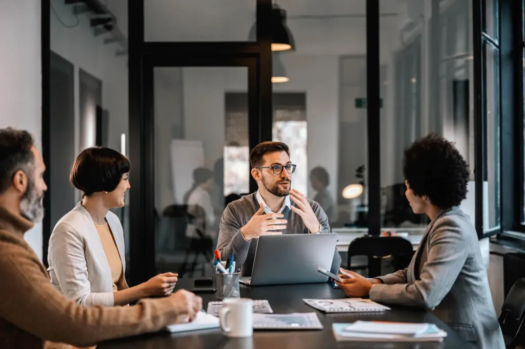 Colleagues talking in a conference room. 