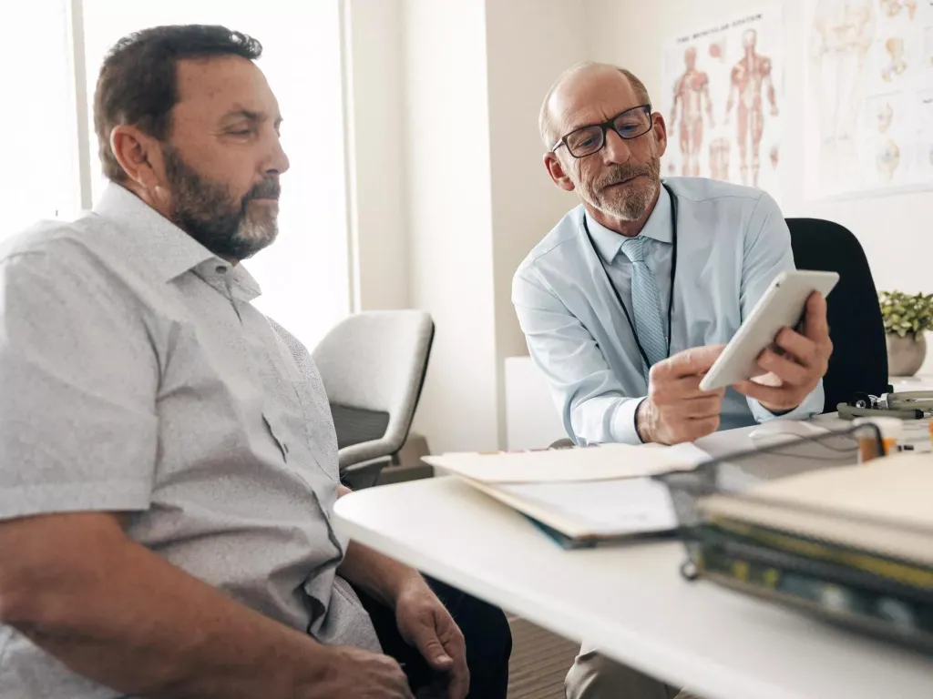 Doctor walking his patient through treatments for his critical illness.
