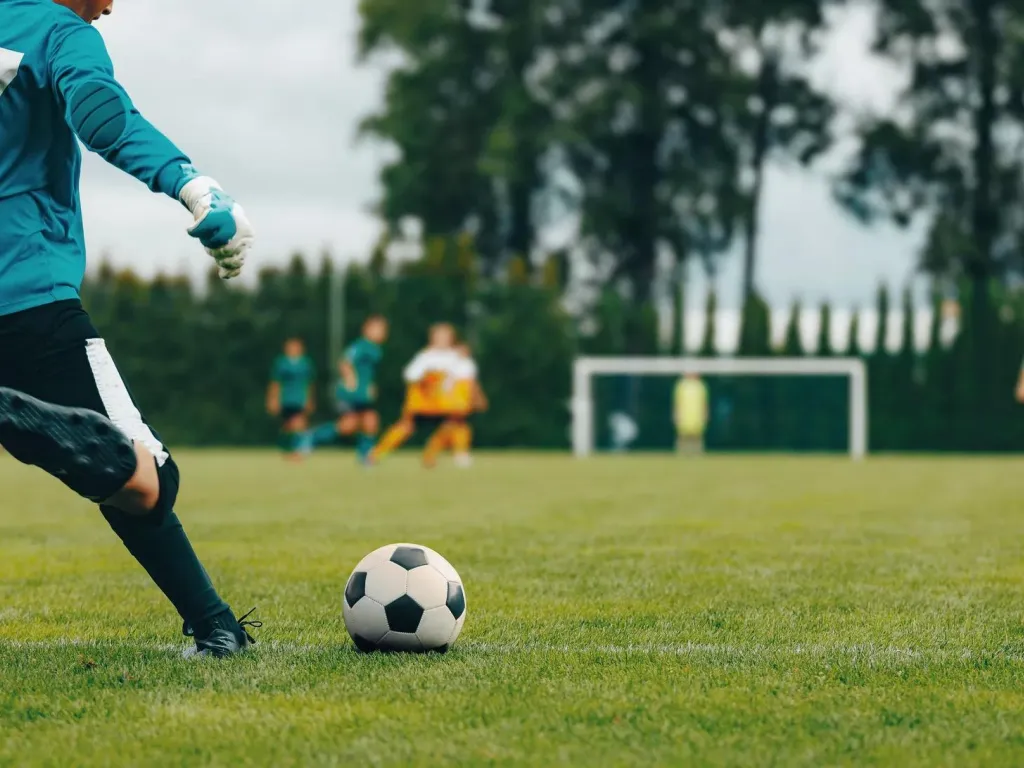 Soccer player about to kick a ball in a high school soccer game.
