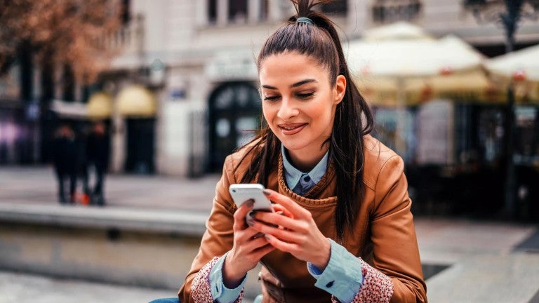 Woman checking investments on her mobile phone.
