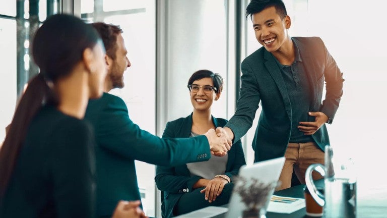 Man shaking hands with co-worker during a new job meeting