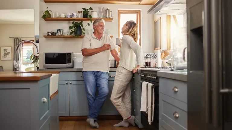 A man and woman happily talking in a kitchen