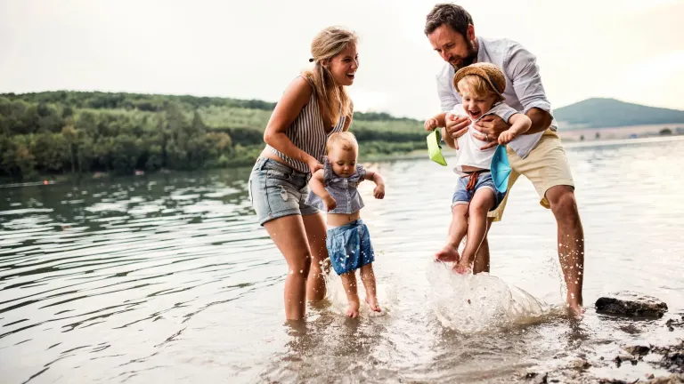 Two parents and two children playing in the water.