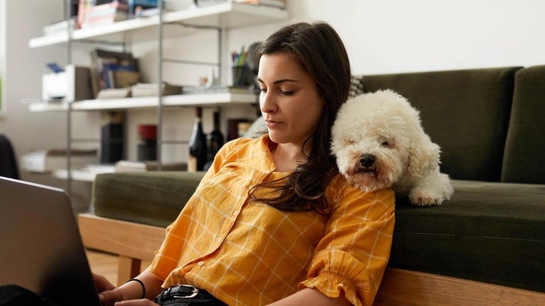 A woman sitting with her dog reviewing her retirement account