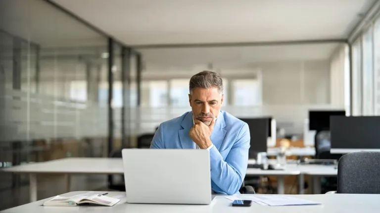 Business executive reading news on a computer