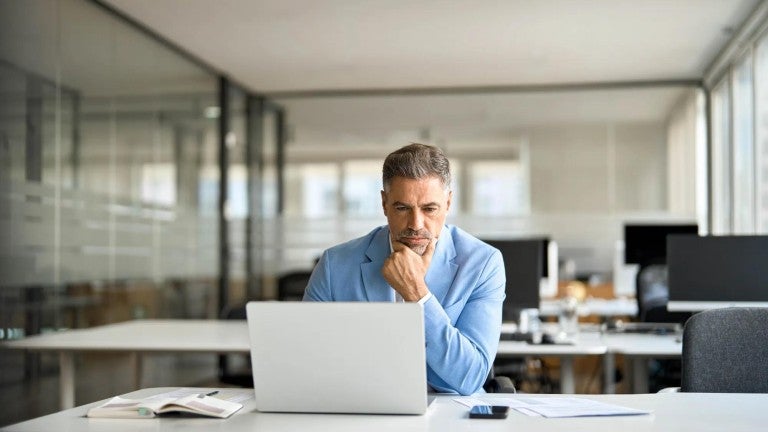 Business executive reading news on a computer