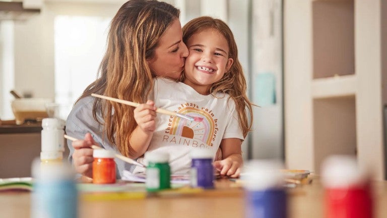 A woman and her daughter painting.