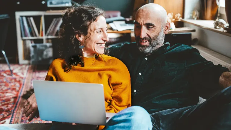 Couple sitting on couch looking at computer