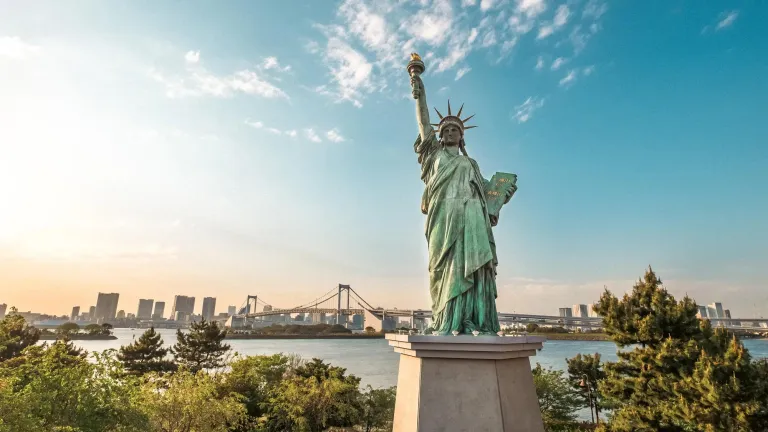 Statue of Liberty overlooking water and city skyline