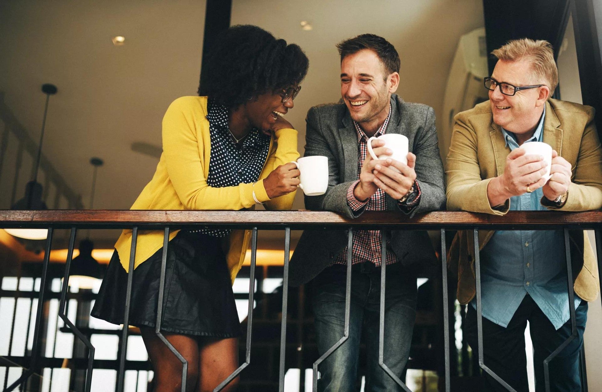 A group of three employees chatting on a balcony. A group of three employees chatting on a balcony.