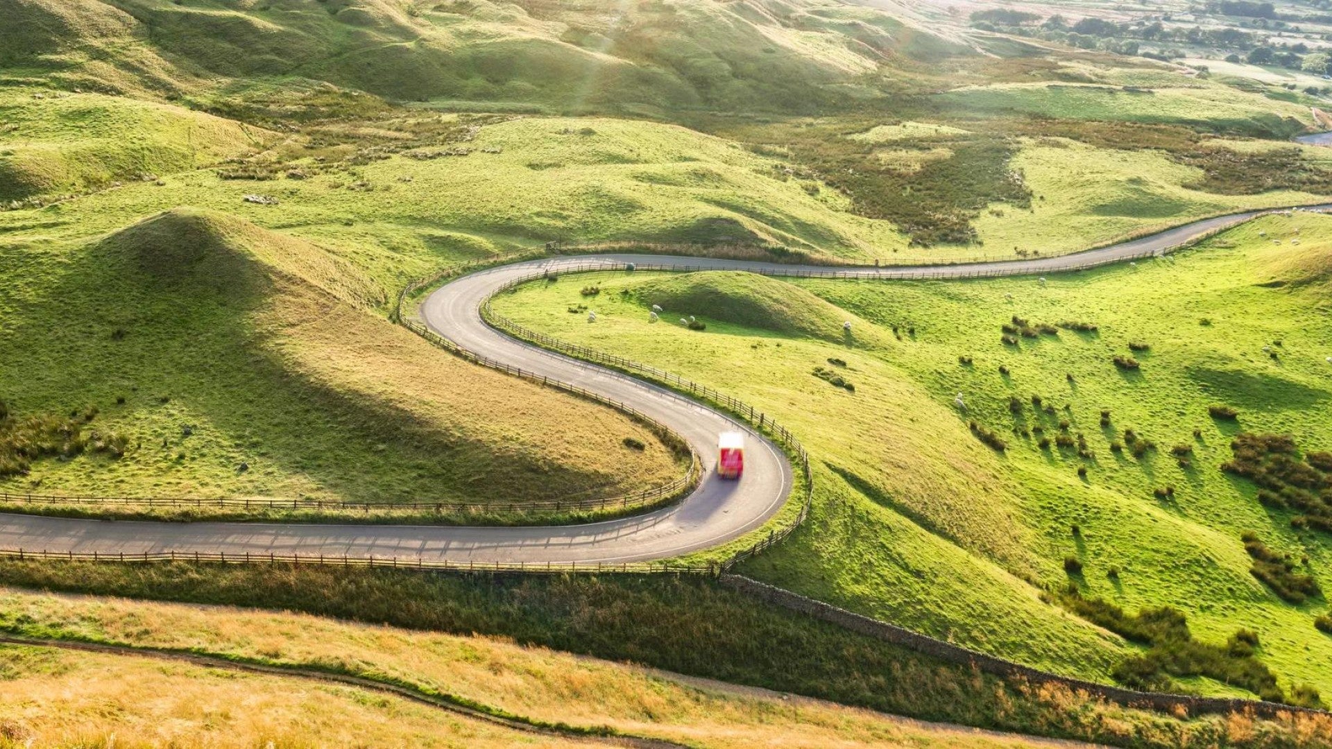 Un coche conduciendo por una carretera sinuosa en un paisaje montañoso