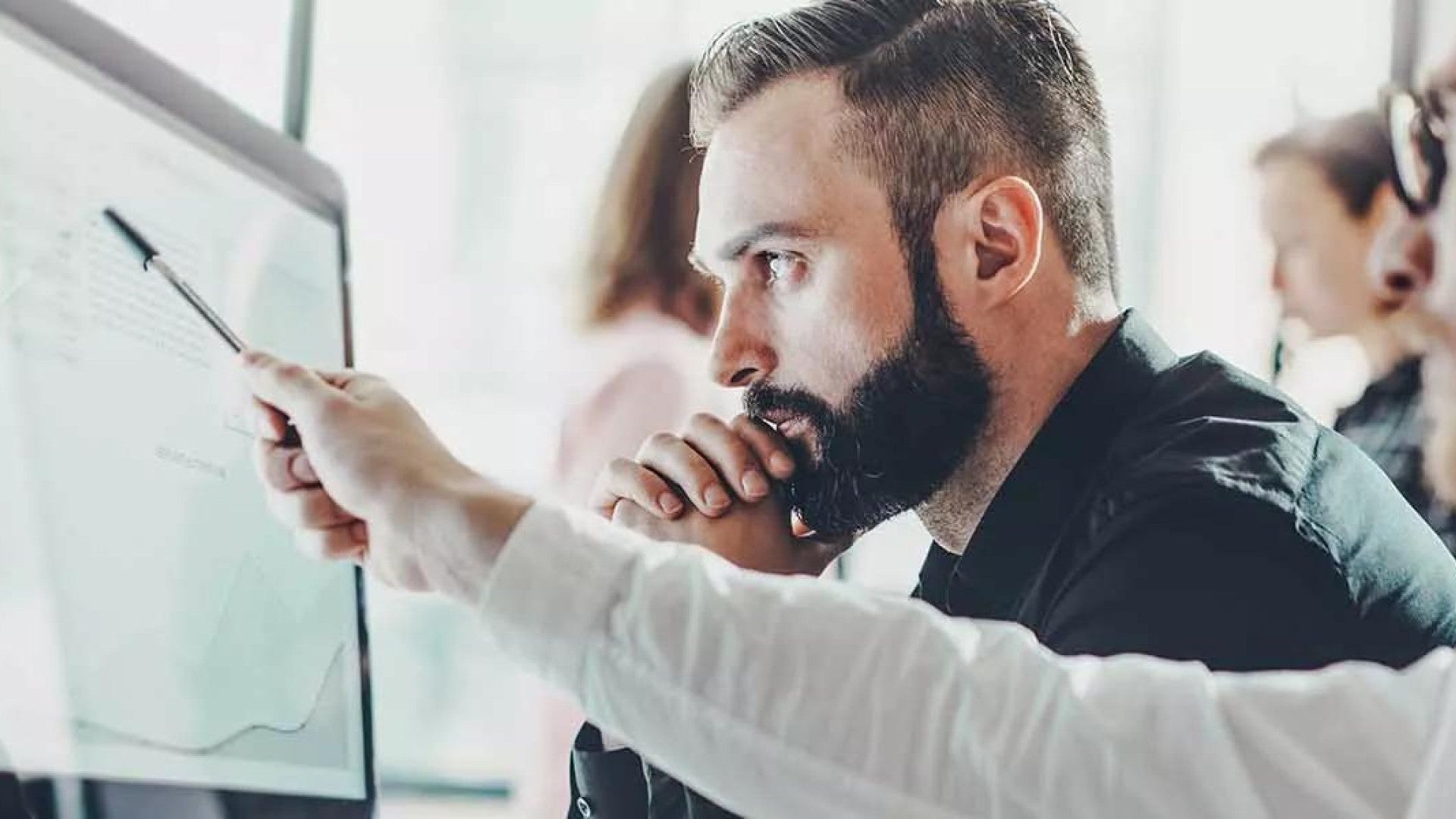 Two men looking and discussing something on a computer screen.