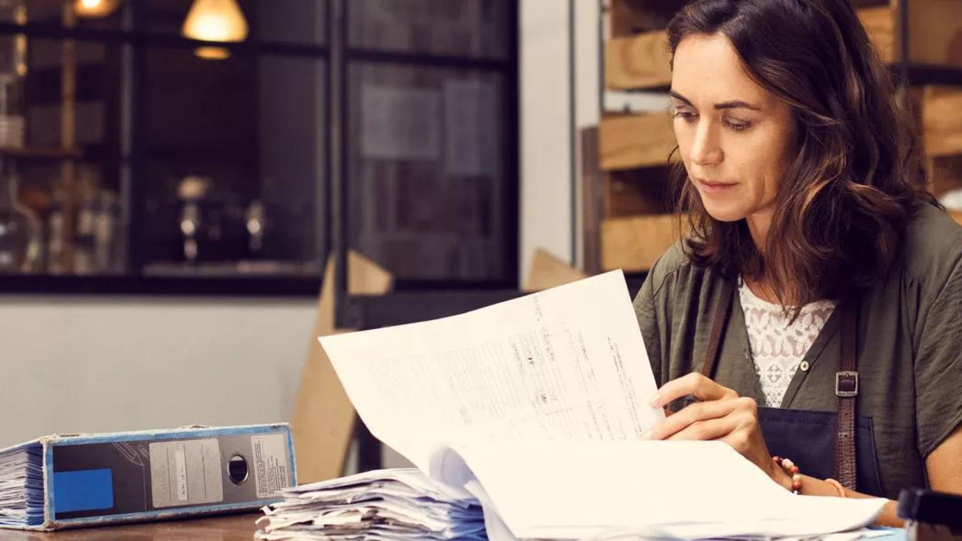 Photo of a woman looking through paperwork. 