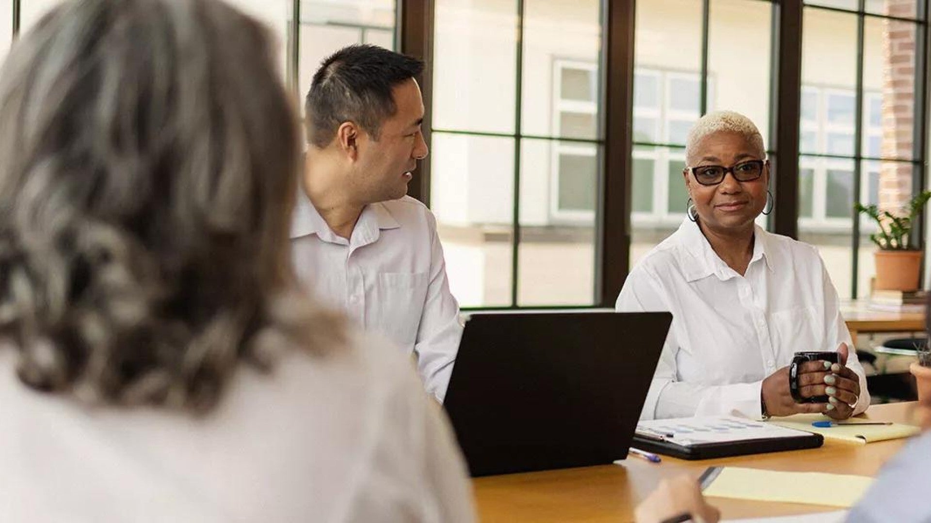 Photo of a group of leaders sitting around a conference table discussing employee benefits.