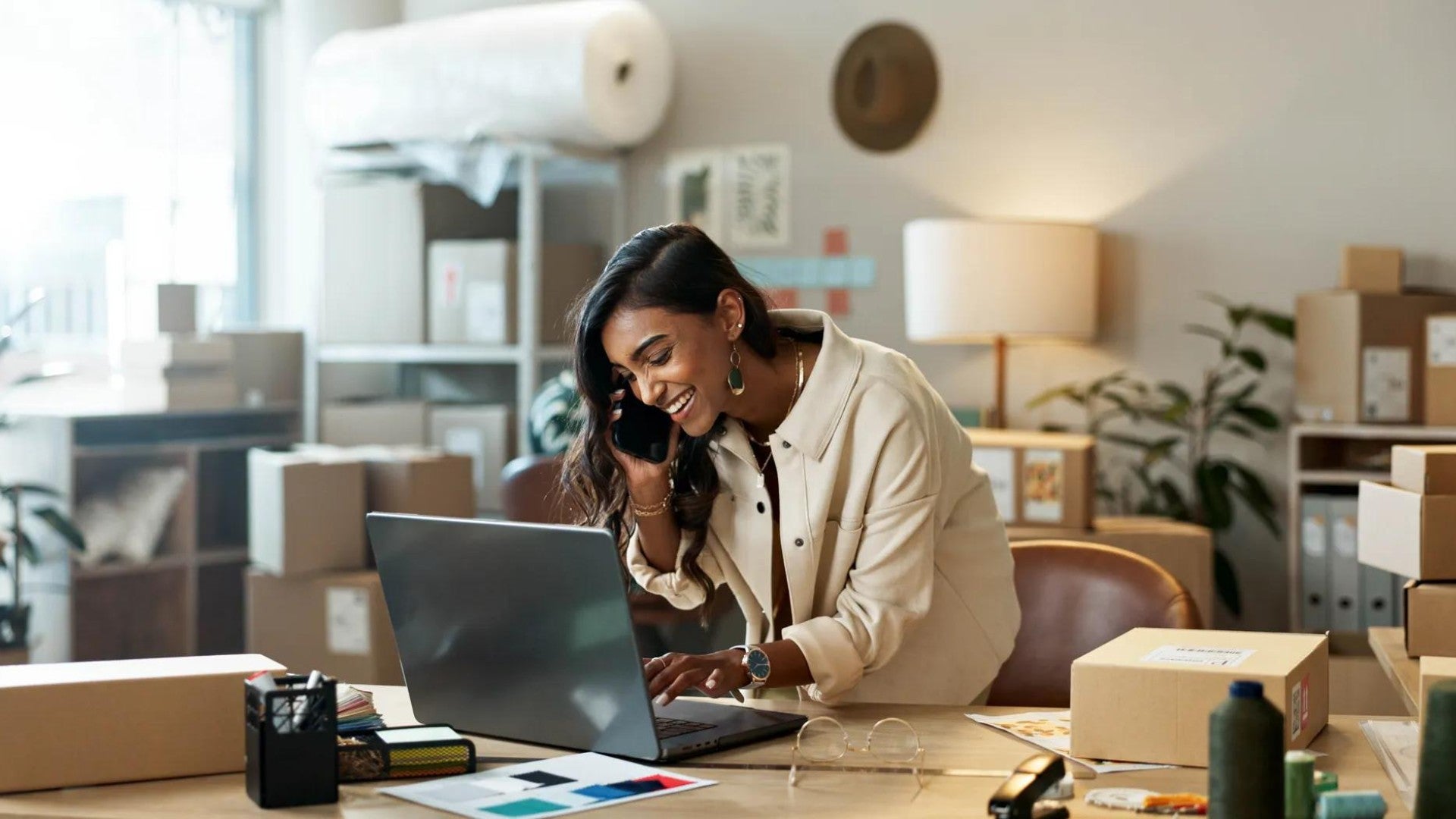 Female business owner in office working on computer.