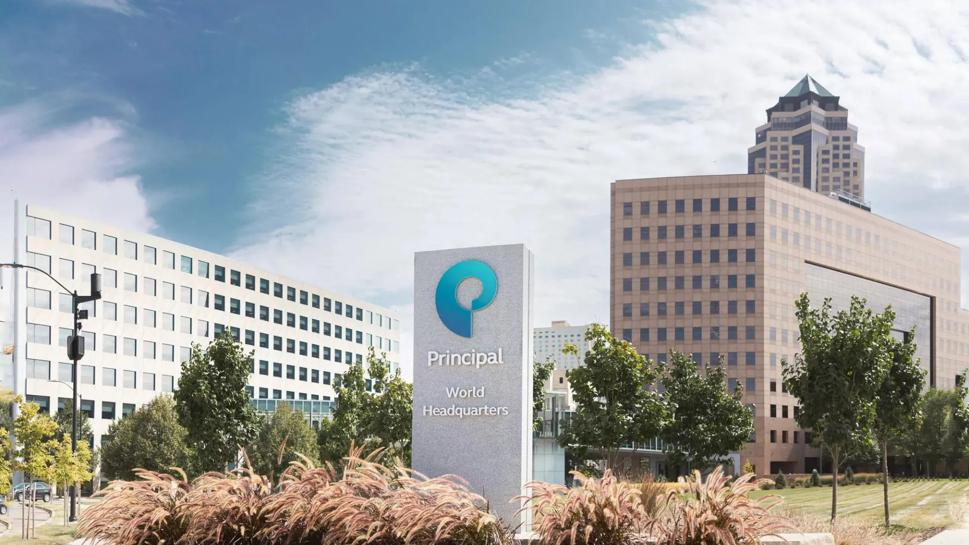 Principal campus signage with notable Des Moines buildings in the background