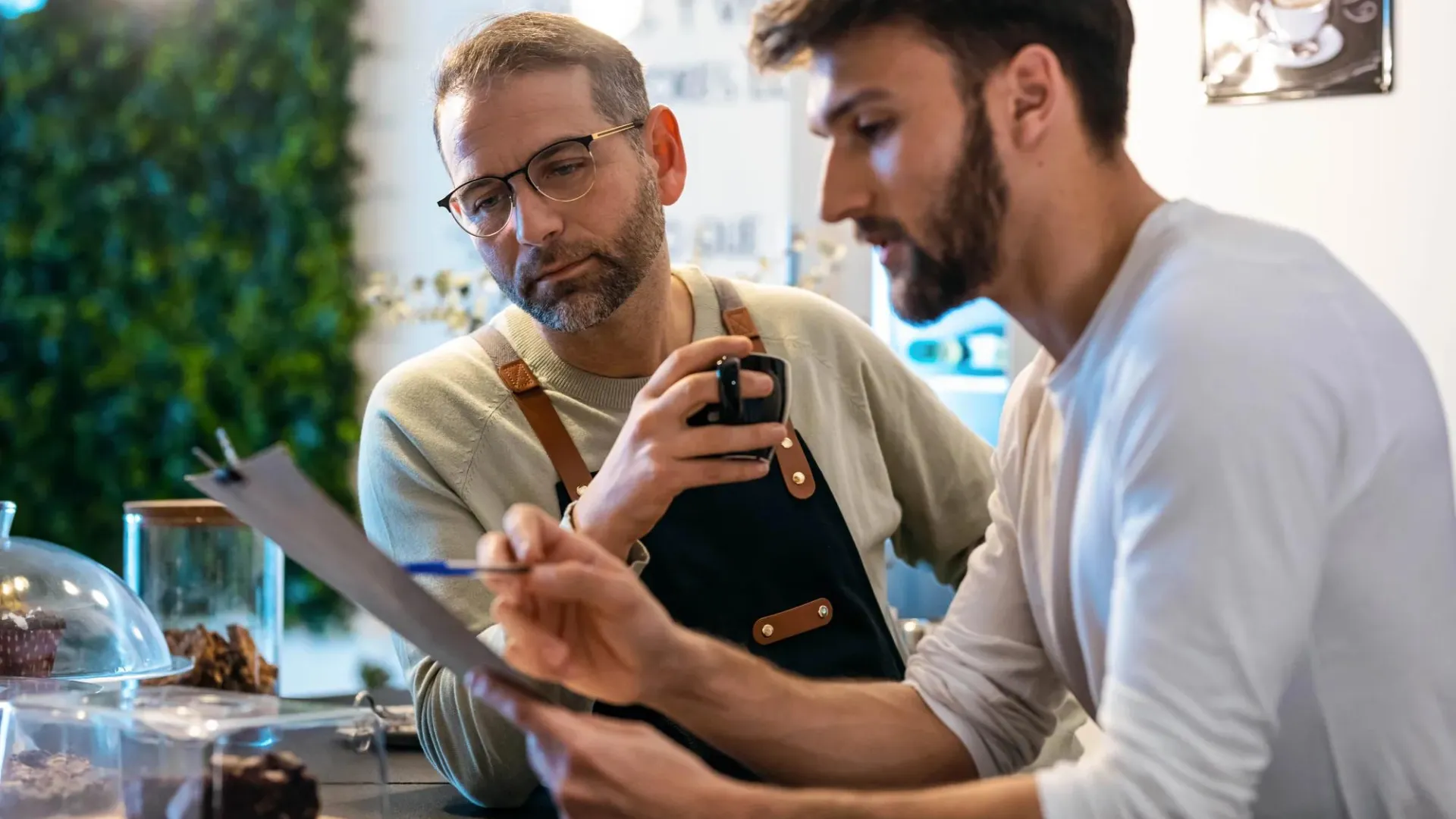 Two men reviewing paperwork while in their shop 