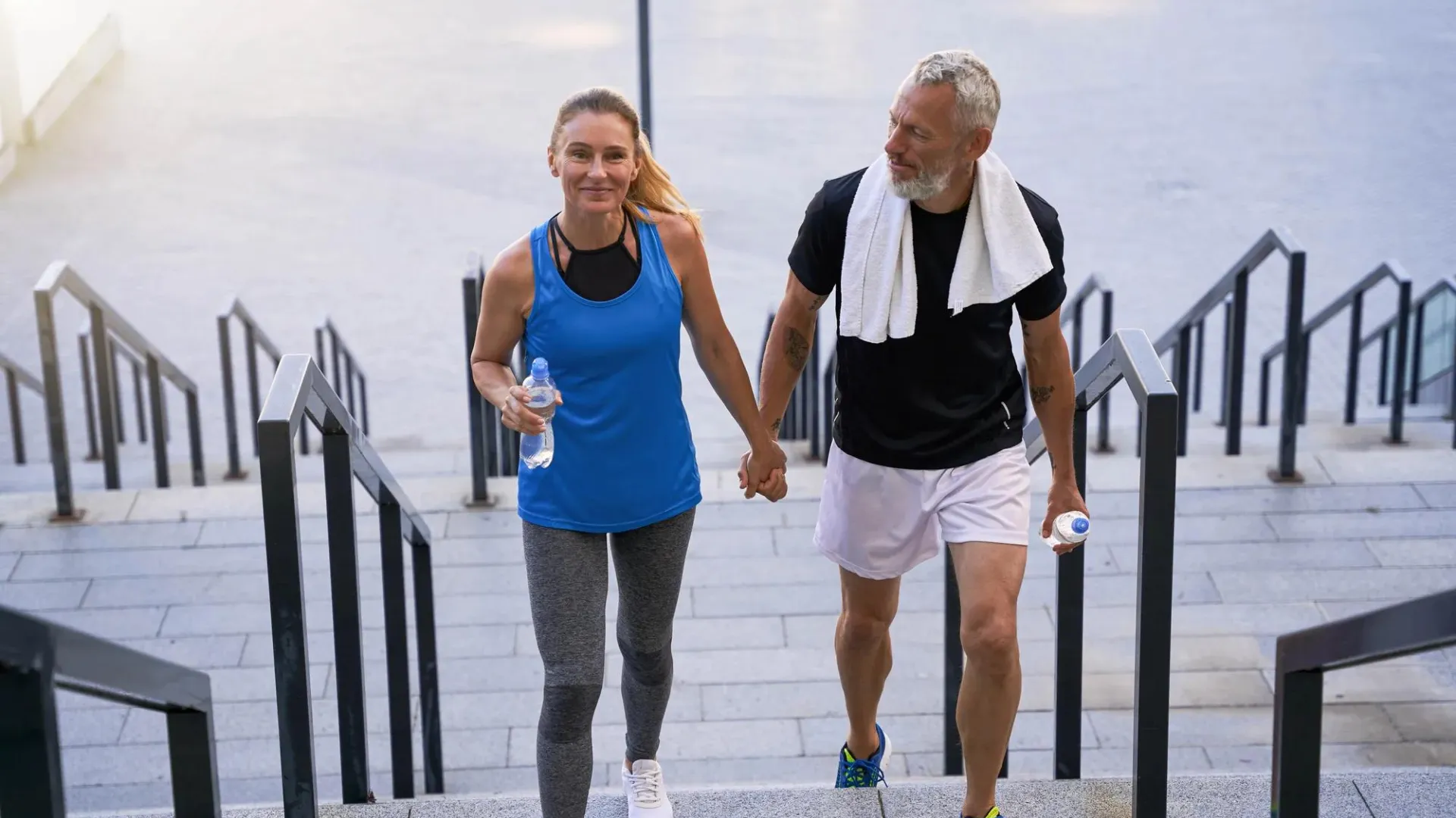 Man and woman in workout clothes on stairs