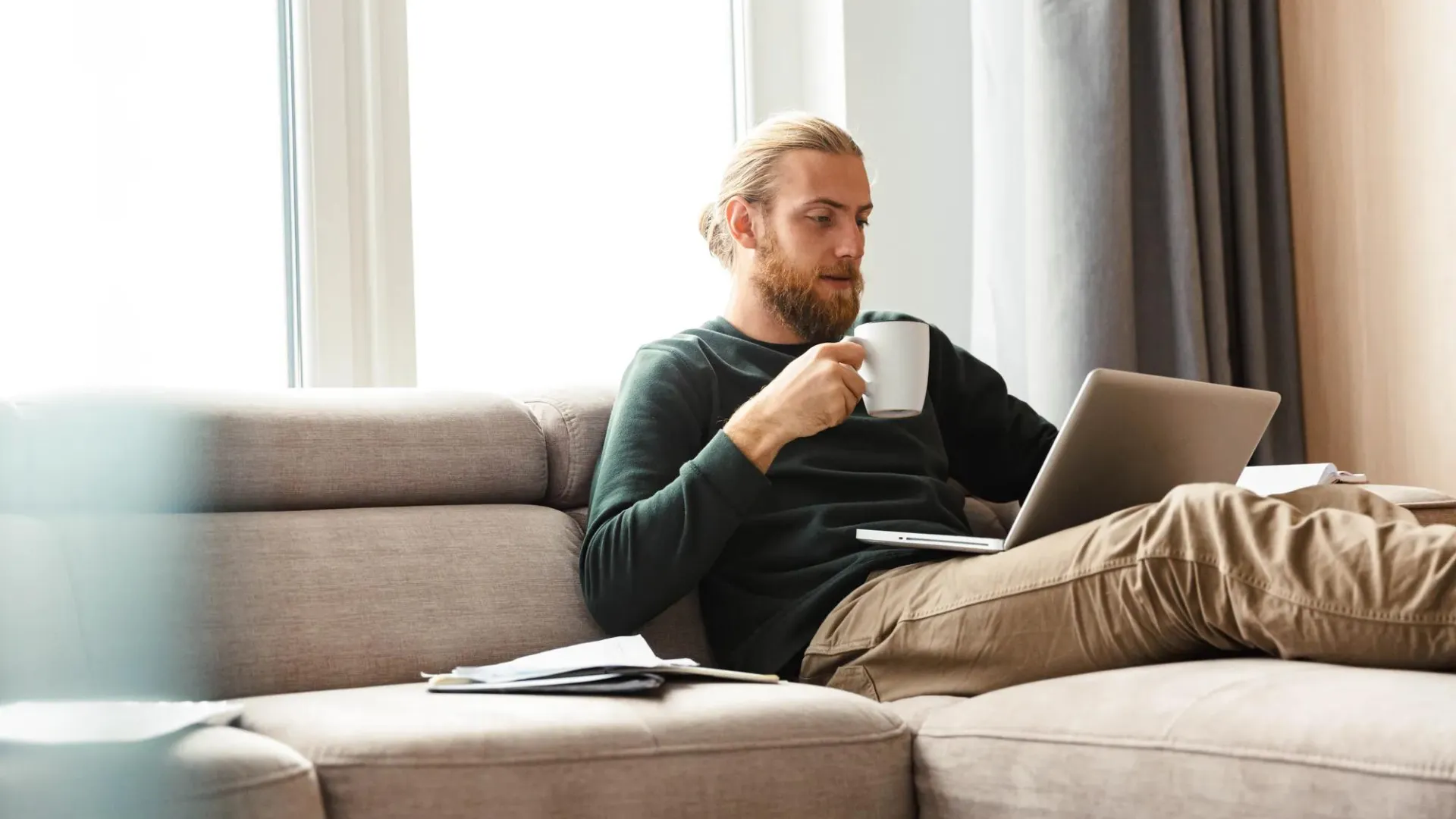 Man sitting on couch looking at computer