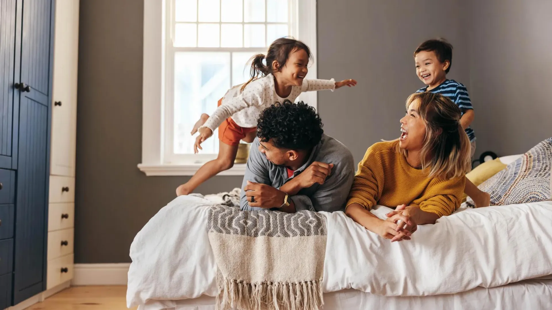 Un padre, una madre y sus dos hijos jugando juntos.