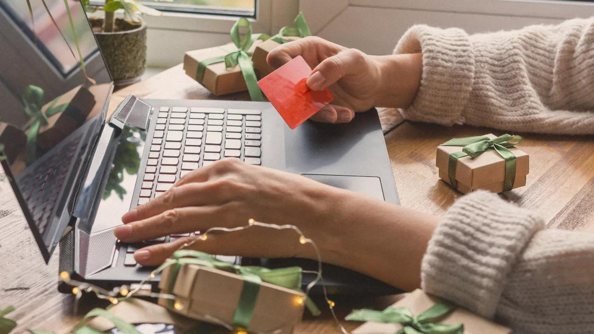 Persona sentada frente a una computadora realizando una compra en línea.