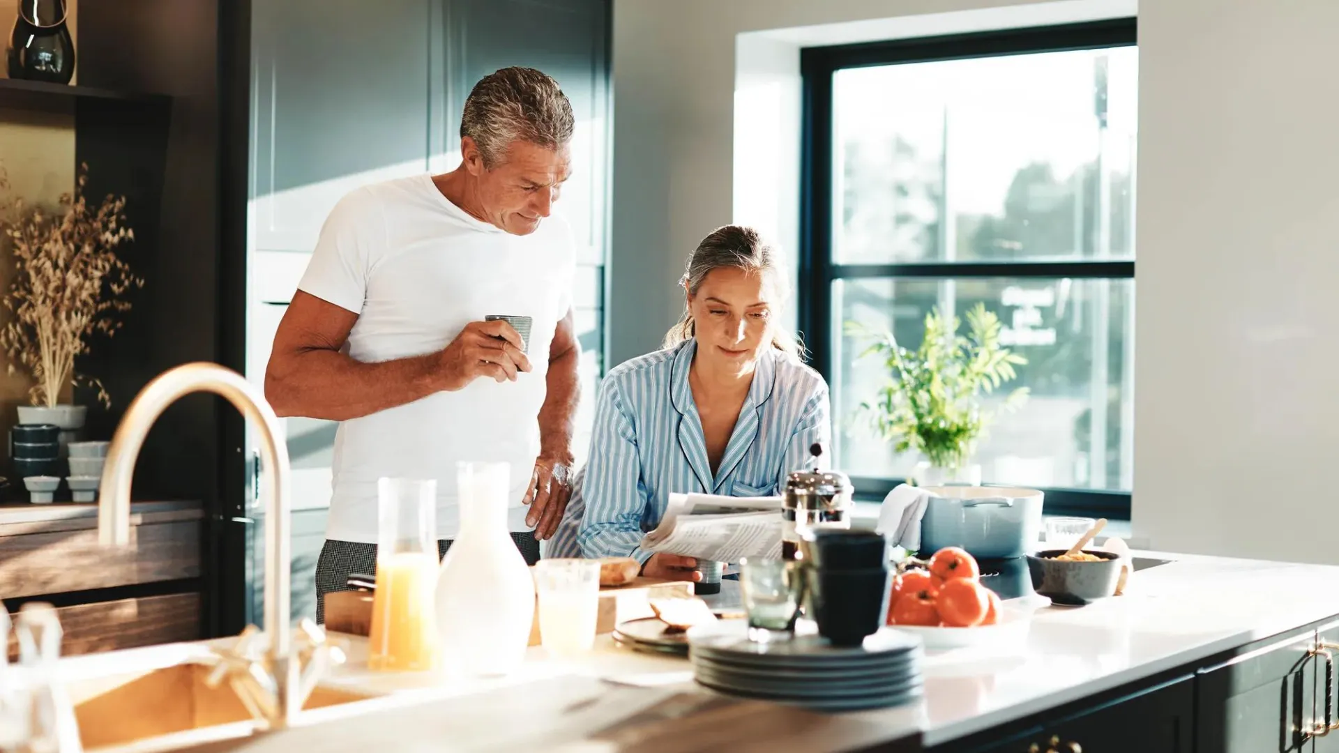 A married couple in their house looking at papers.