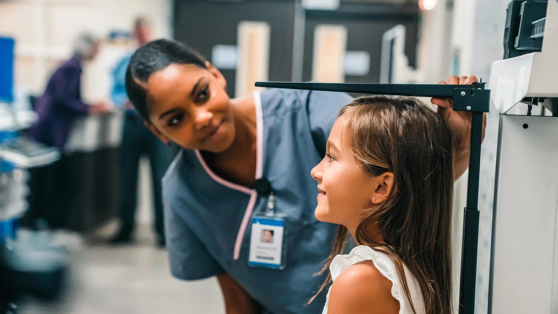 Nurse measuring height of girl