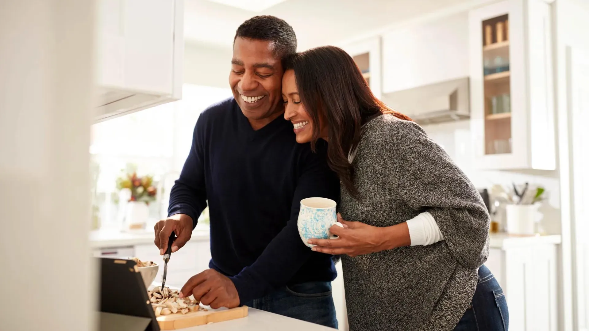 Couple reviewing retirement plan at computer, woman seated at desk.