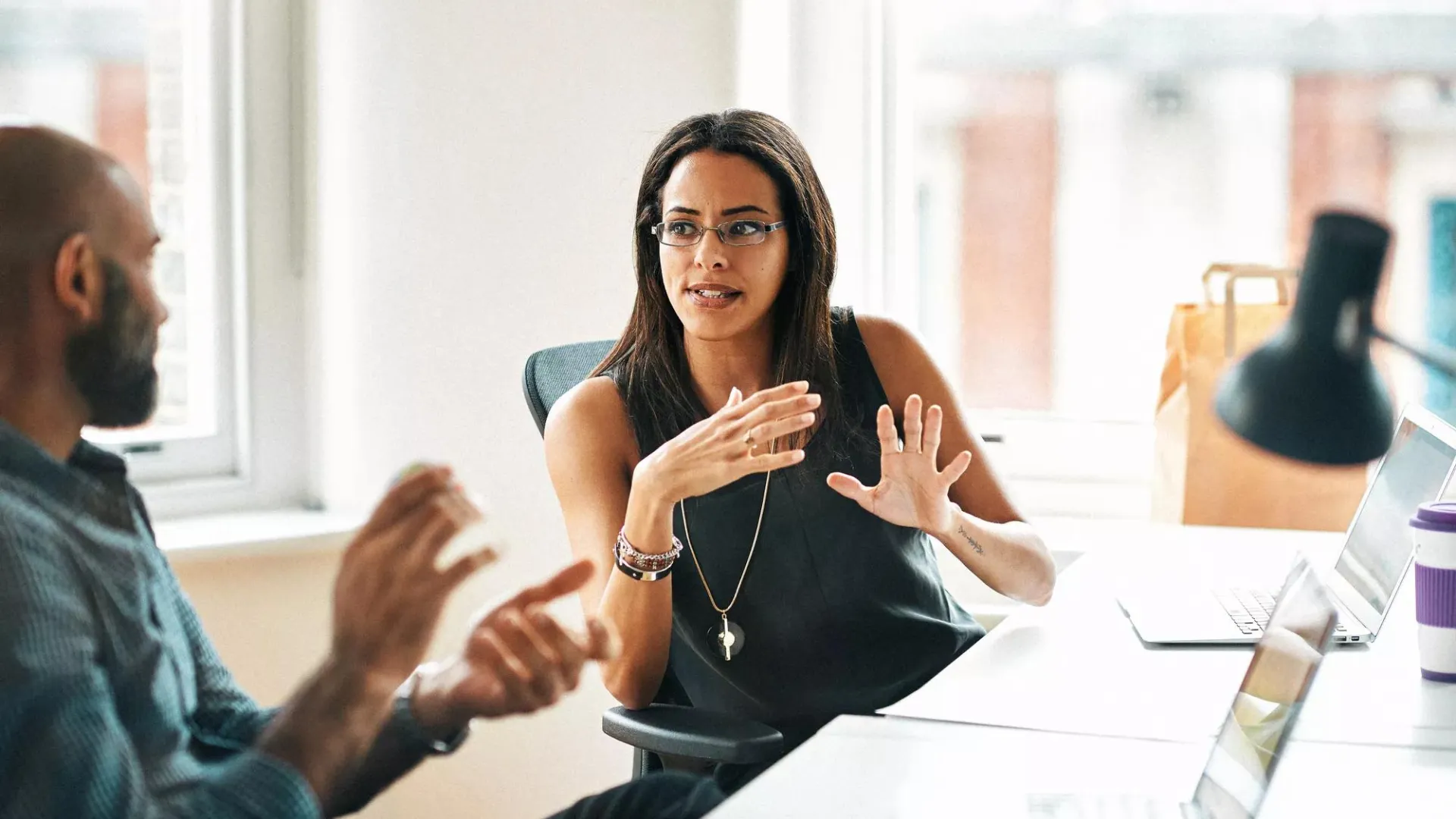A woman and man in an office setting having a discussion.
