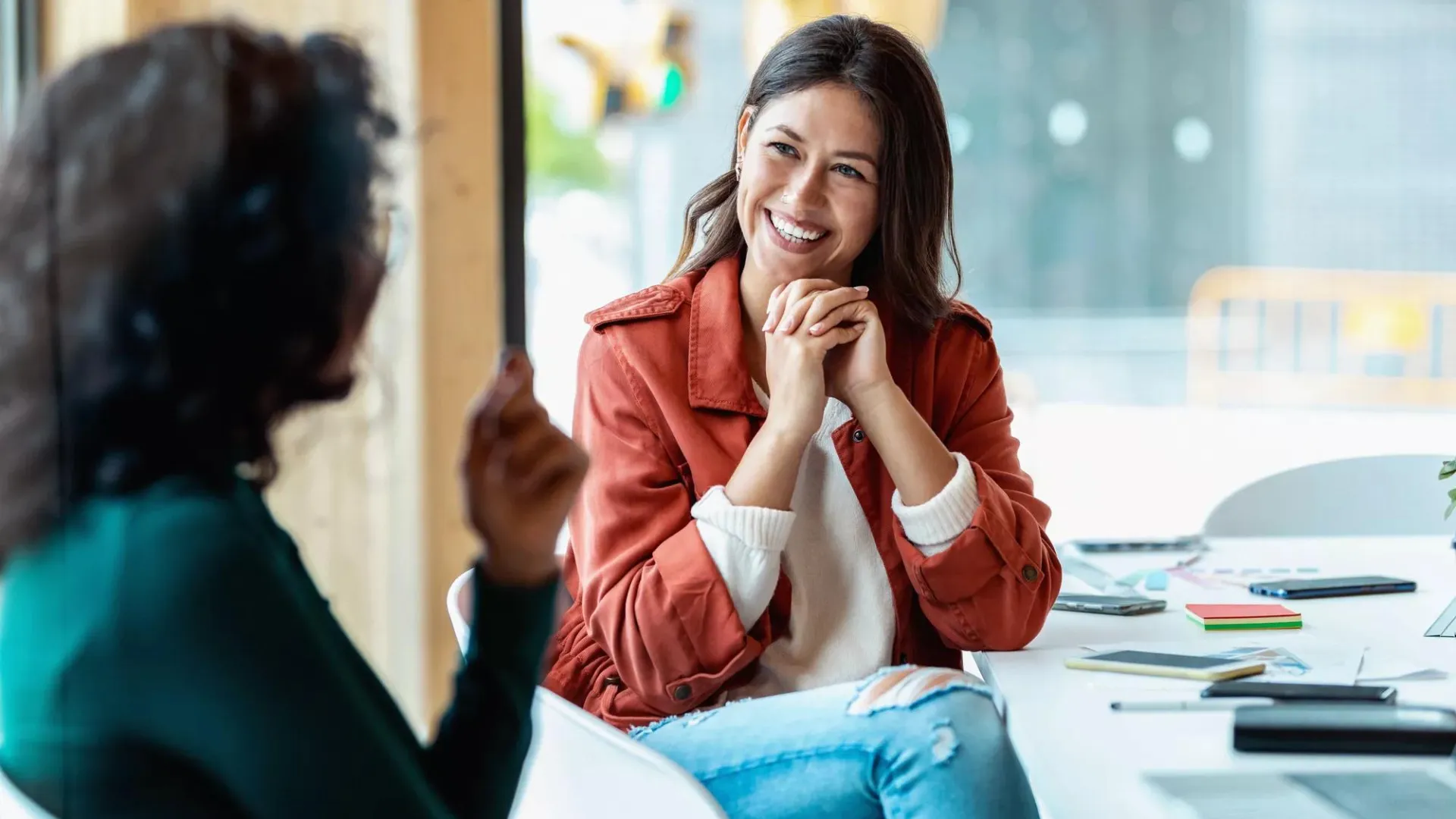 Woman in office environment smiling at a colleague.