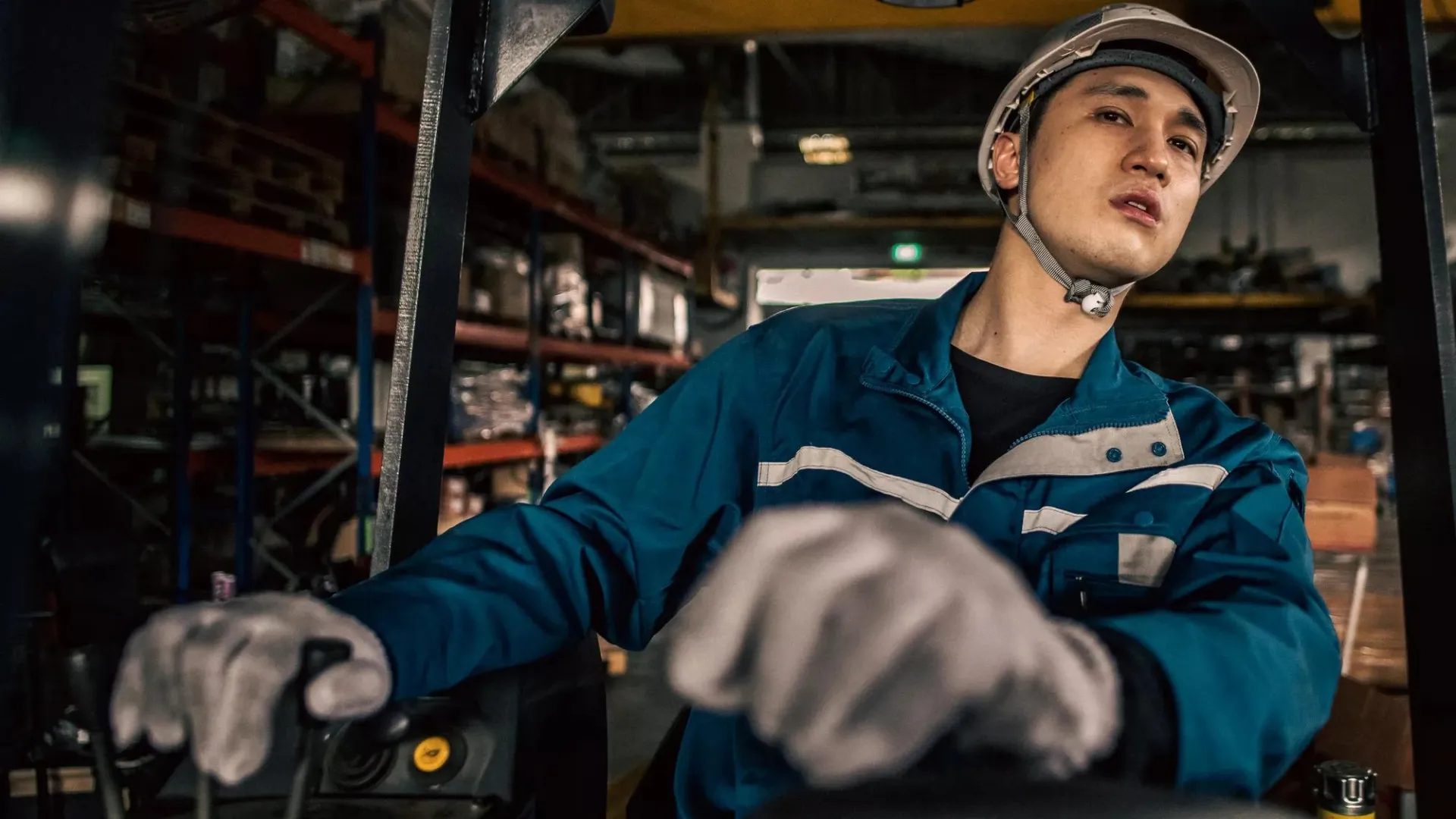 Asian male factory worker operating a forklift