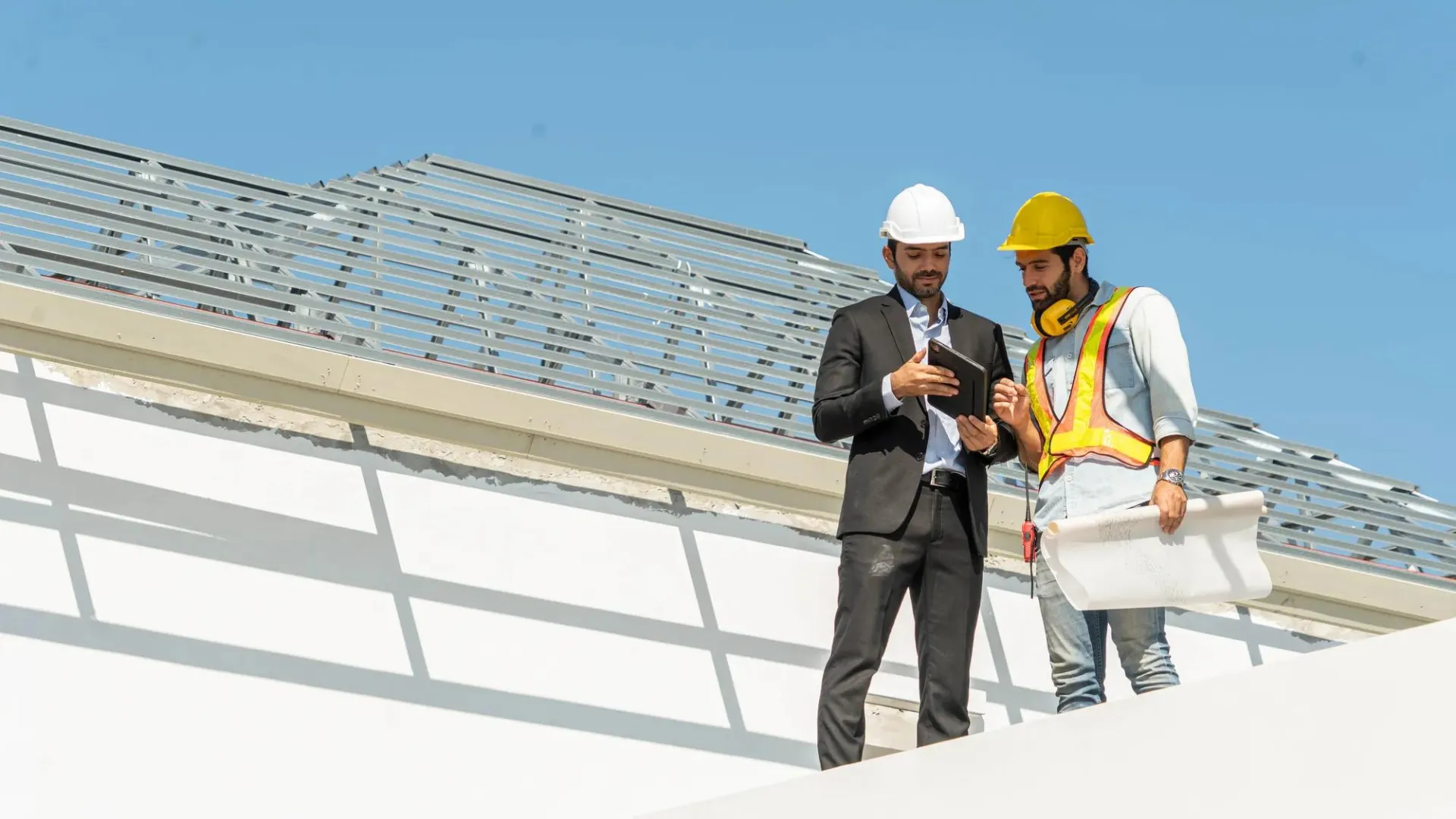 A business owner and employee discuss a project at the worksite.