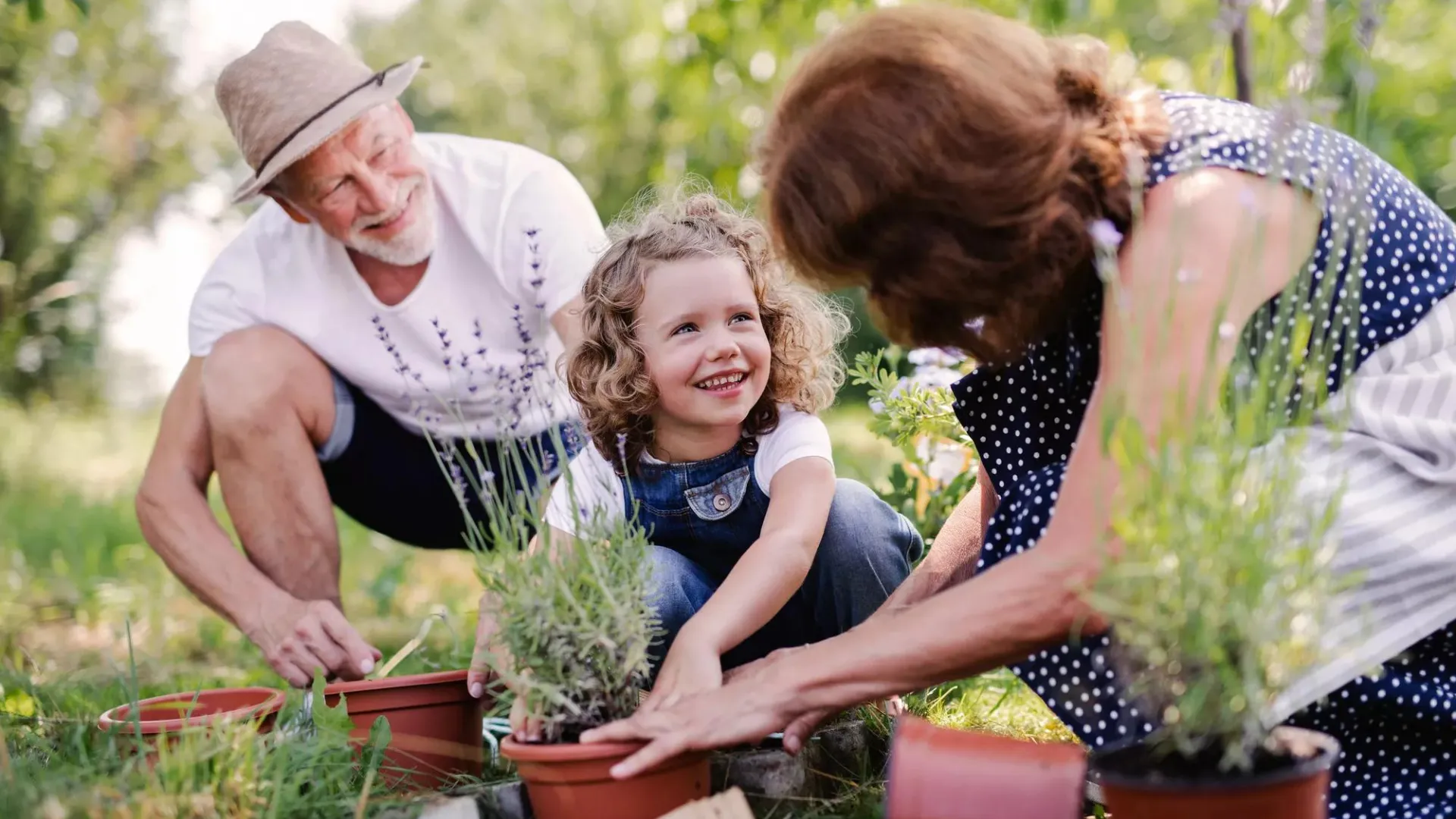 Older couple gardening with their grandchild.
