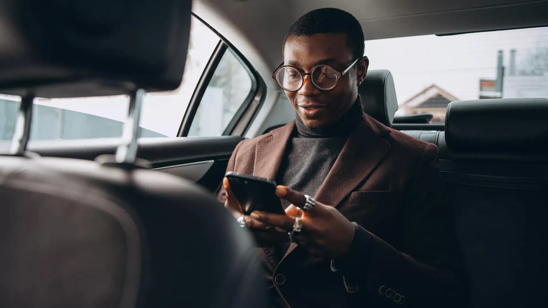 Man in suit looking at his phone to check personal information.