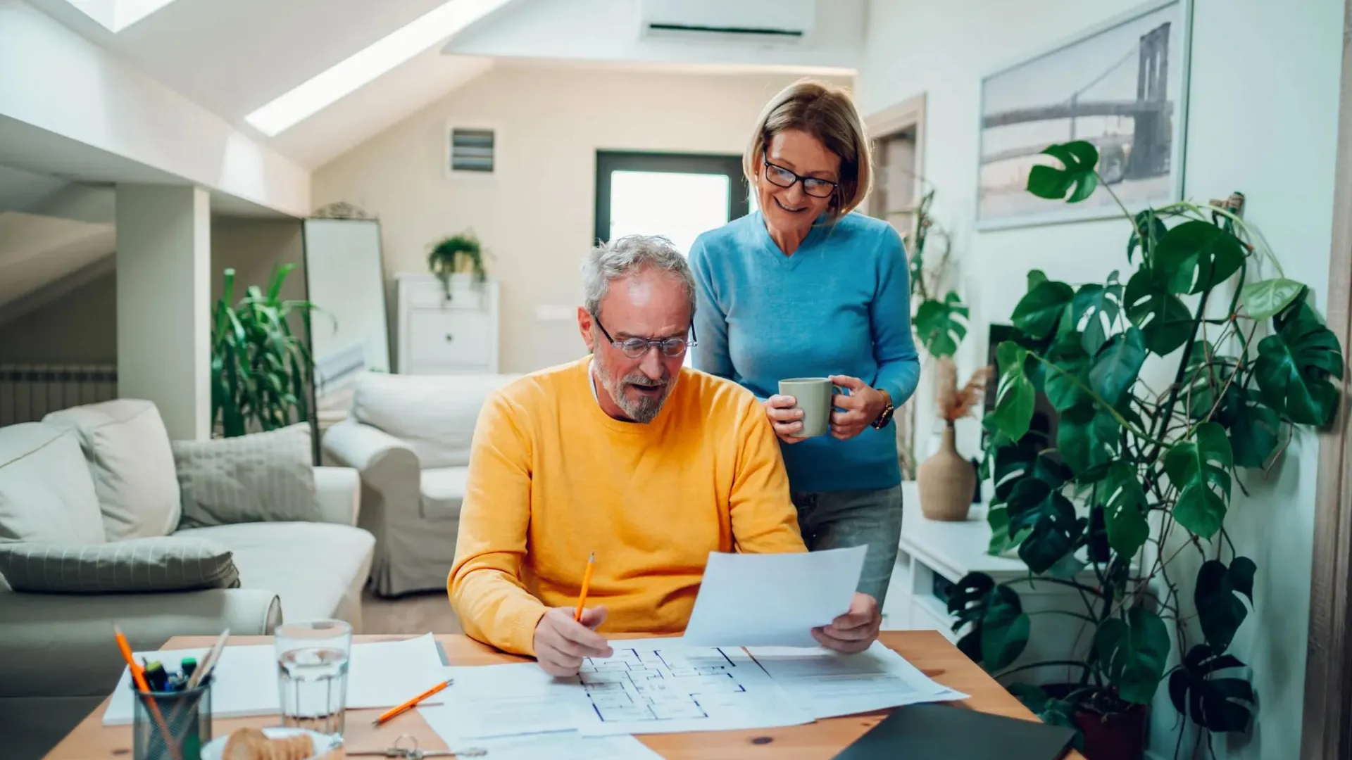 Couple in a home office reviewing financial paperwork