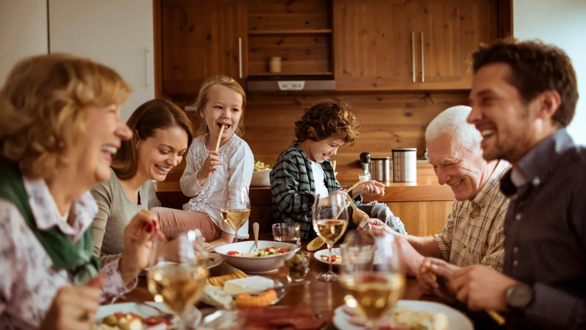 A happy family eating around a table.