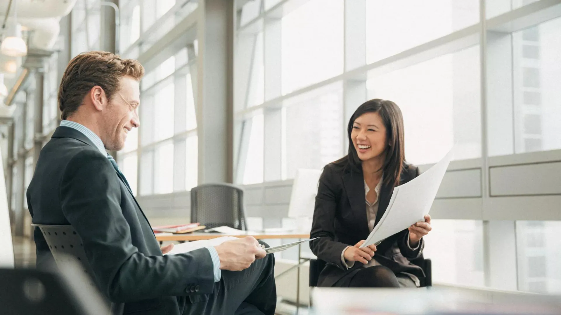 Two business people smiling as they review their defined benefits strategy