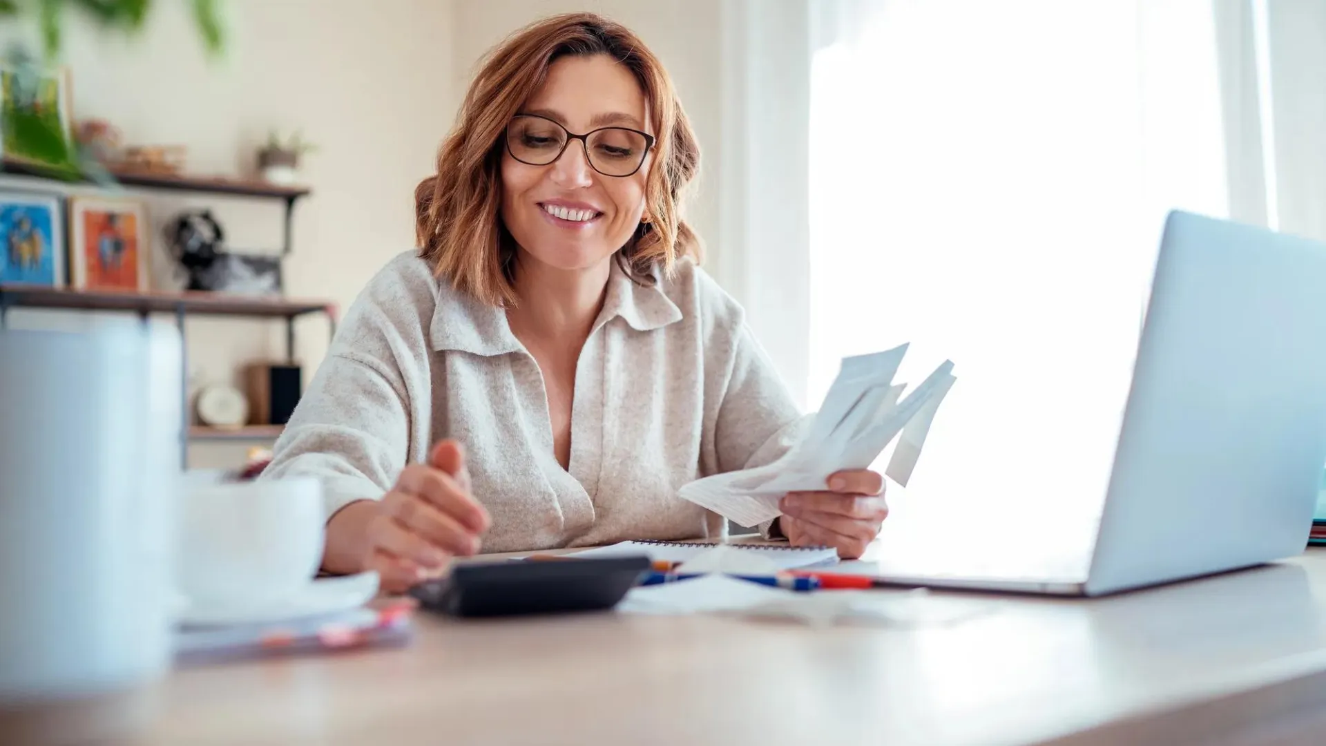 A woman reviewing her finances to make financial trade-offs