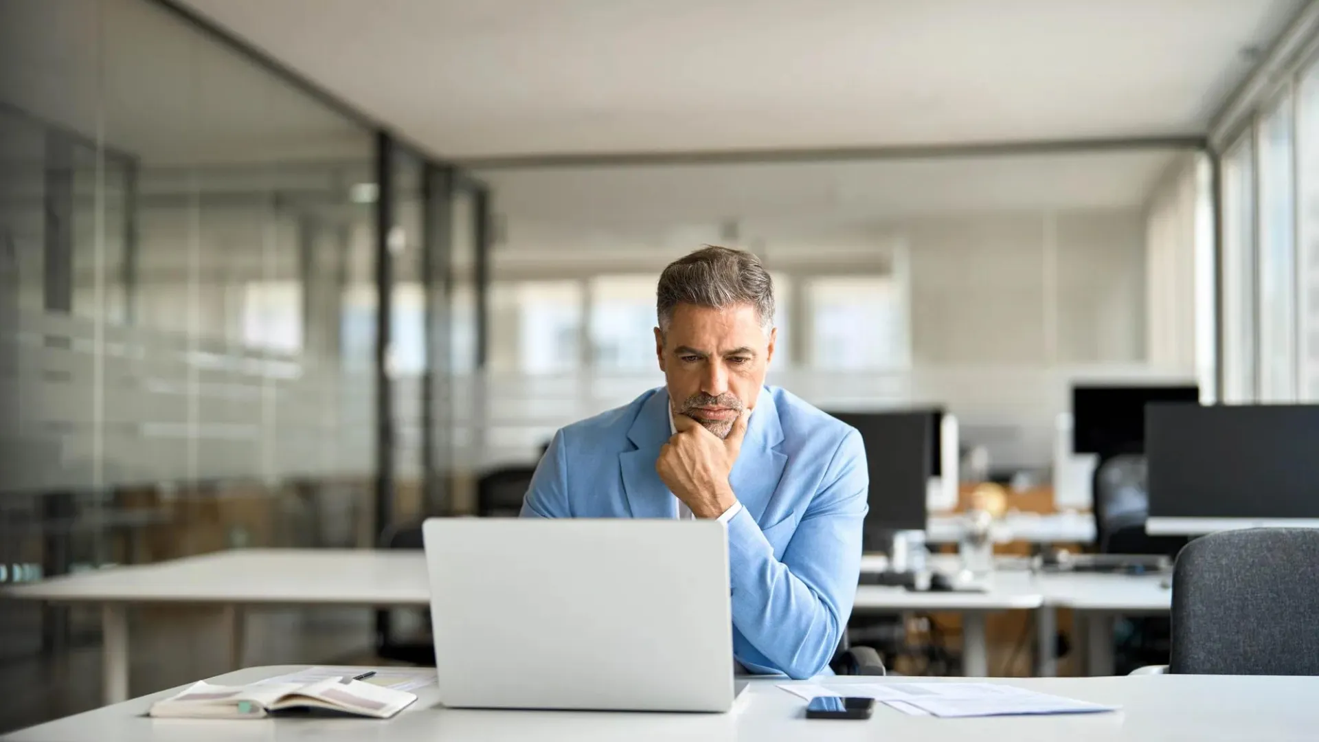 A man sits at his computer trying to stay up to date with tarrifs